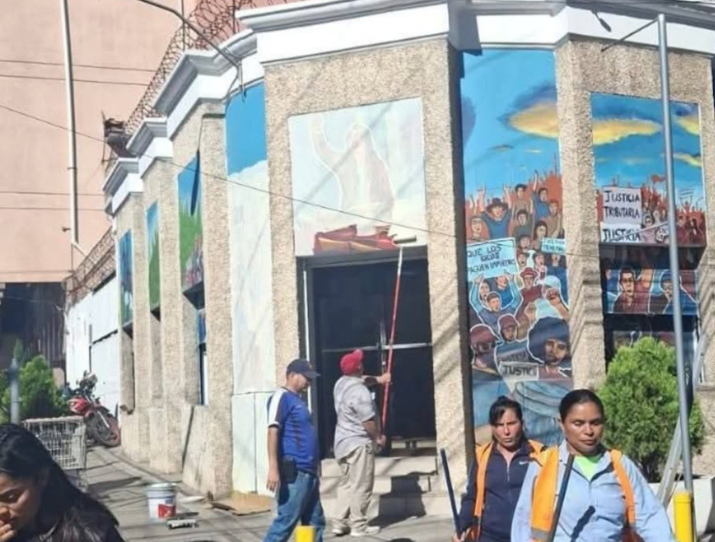 Imagen cuando pintores borran los murales de la Secretaría de Finanzas en Tegucigalpa.